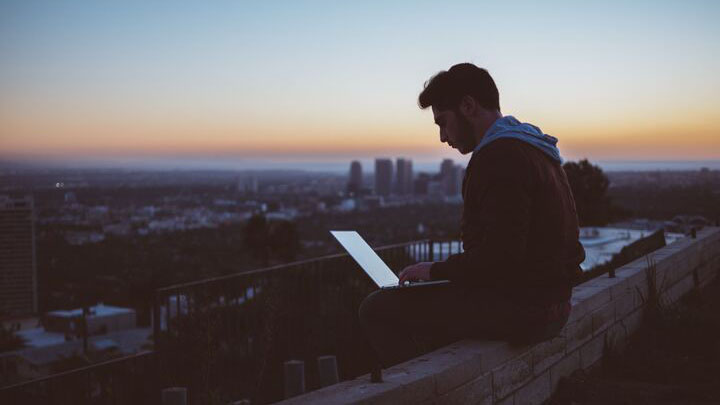 Person on laptop with view of skyline