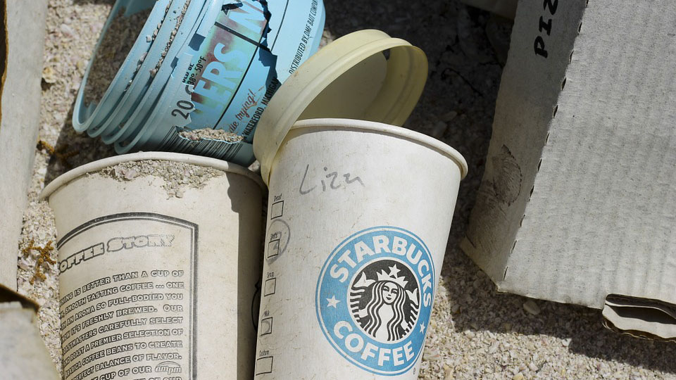 trashed coffee cups, including a Starbucks cup with the name Liza on it