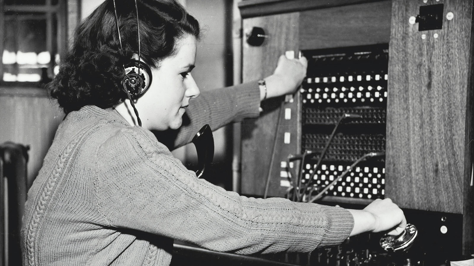 Woman operating an old telephone system