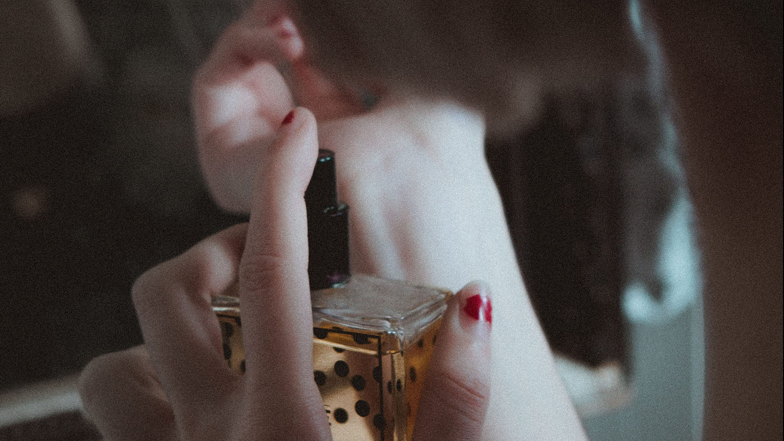 Woman spraying perfume on her wrist