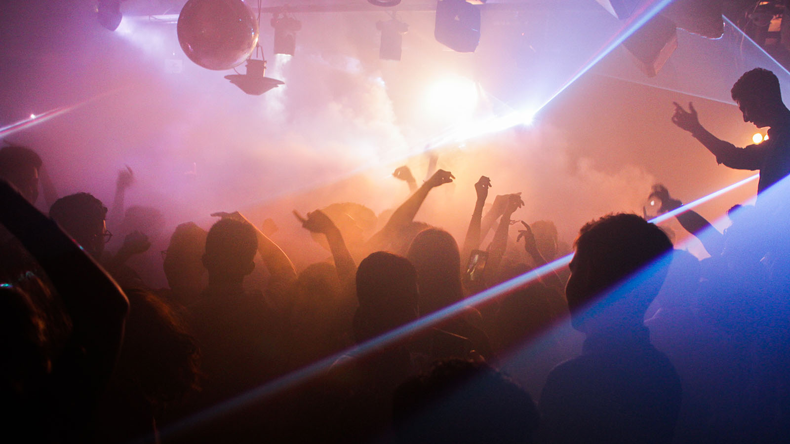 People dancing at a concert with a fog machine